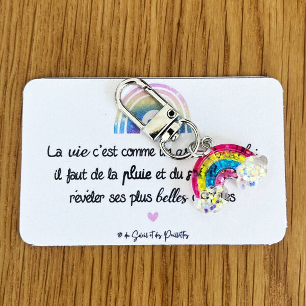 Argenté, pailleté, plein de couleurs, le porte-clé arc-en-ciel s'offre avec le cœur à une amie qui en a besoin